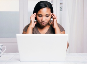 Young woman using laptop, looking stressed, Cape Town, Western Cape Province, South Africa